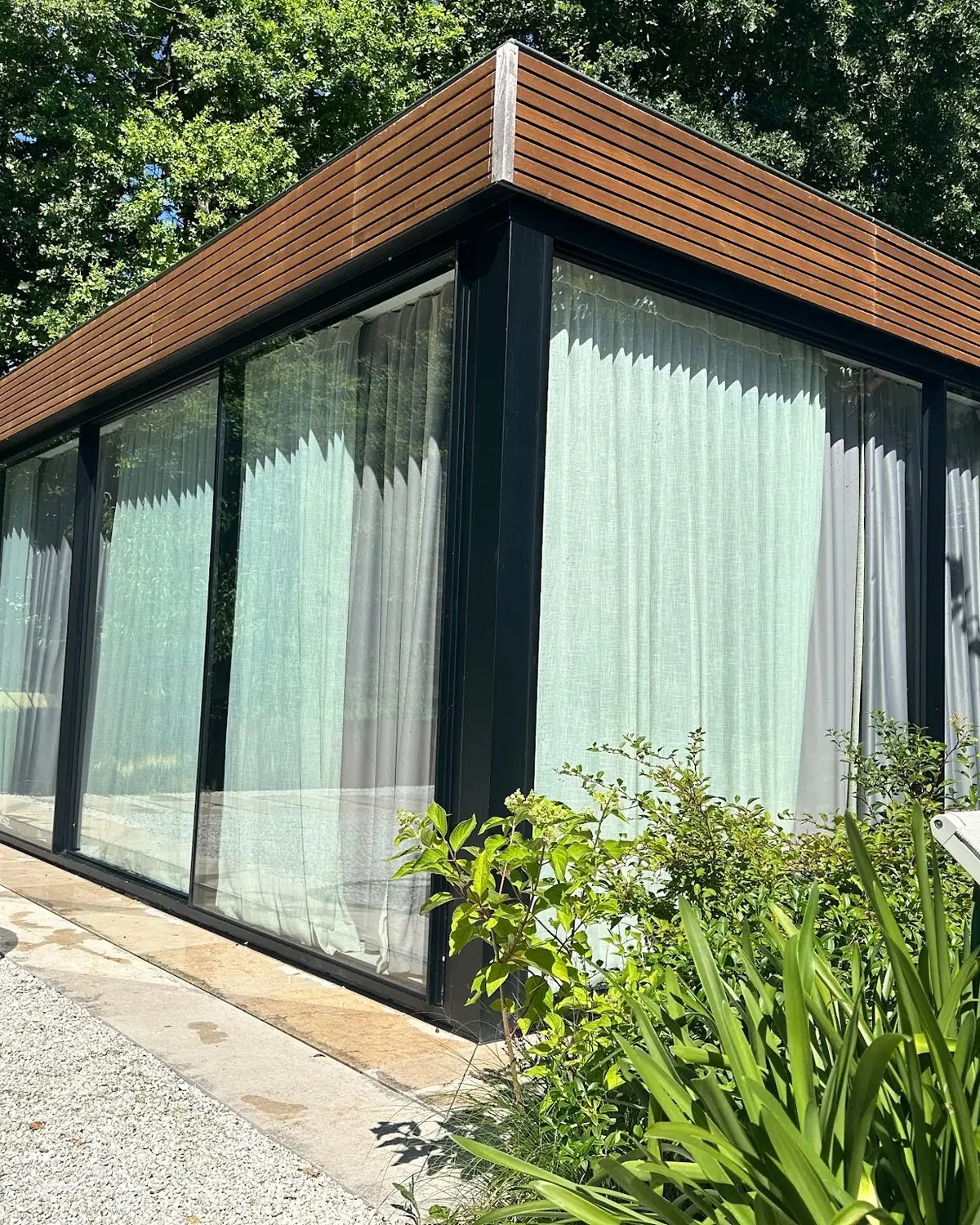 Pavillon de piscine vitré dans un jardin